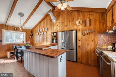 a kitchen with stainless steel appliances granite countertop a refrigerator and a stove