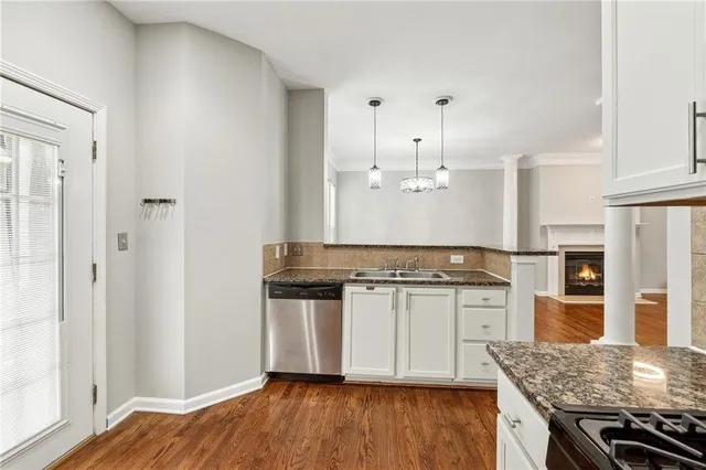 a kitchen with stainless steel appliances granite countertop a stove and a wooden floors