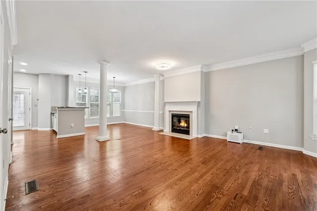 a view of empty room with wooden floor and fireplace