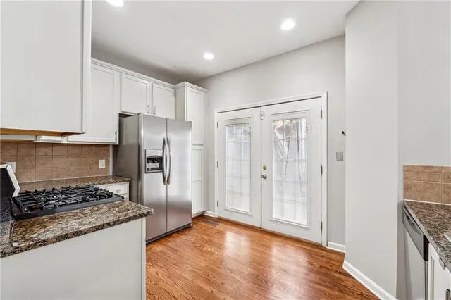 a kitchen with stainless steel appliances granite countertop a refrigerator and a stove