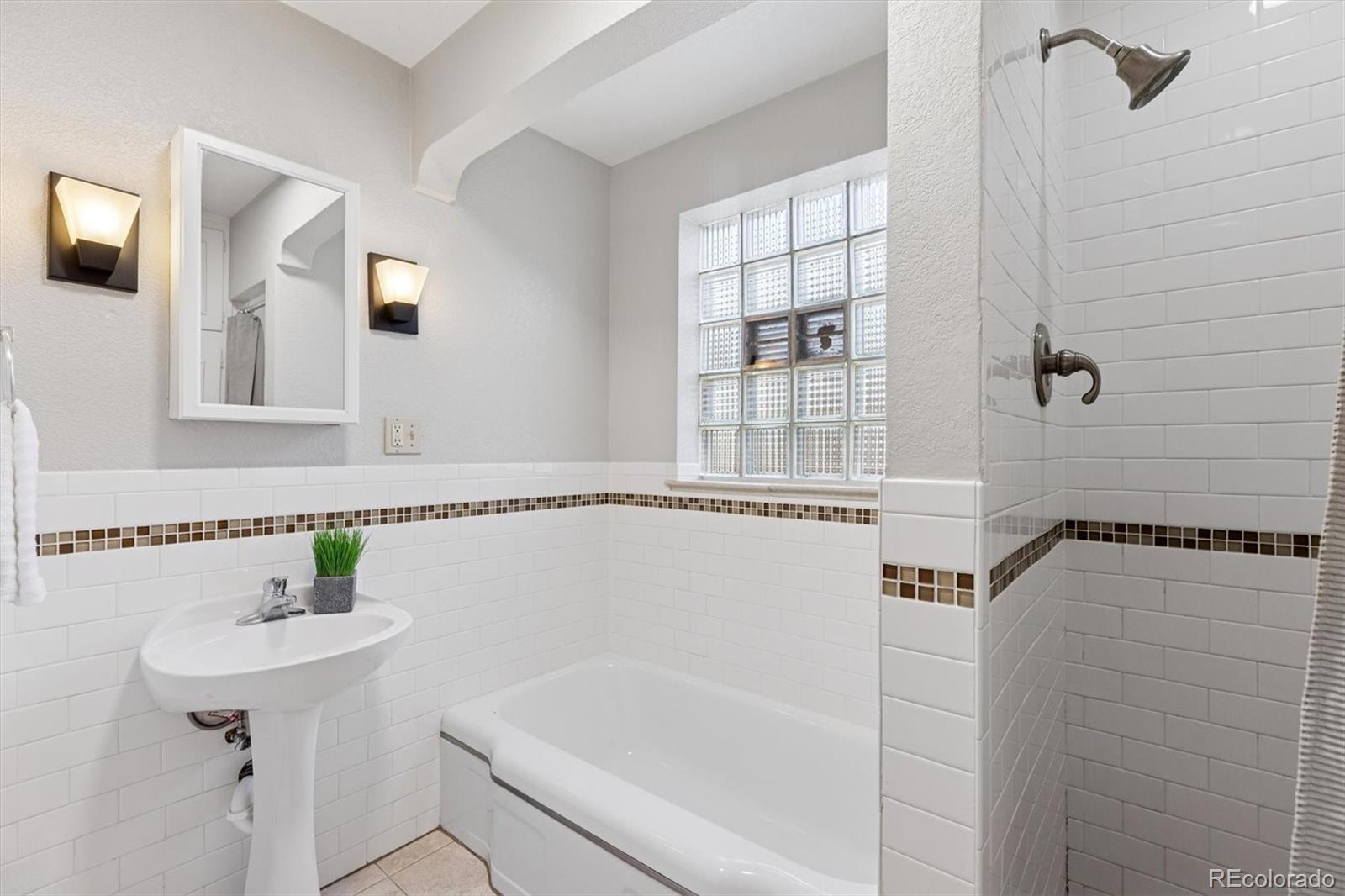 4675 Balsam Street Wheat Ridge, CO 80033 - Photo 20 of 30 a bathroom with a shower sink and mirror