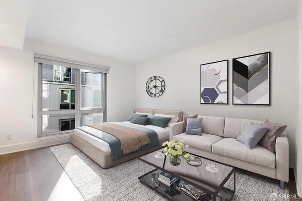 a bedroom with a bed couches and kitchen view