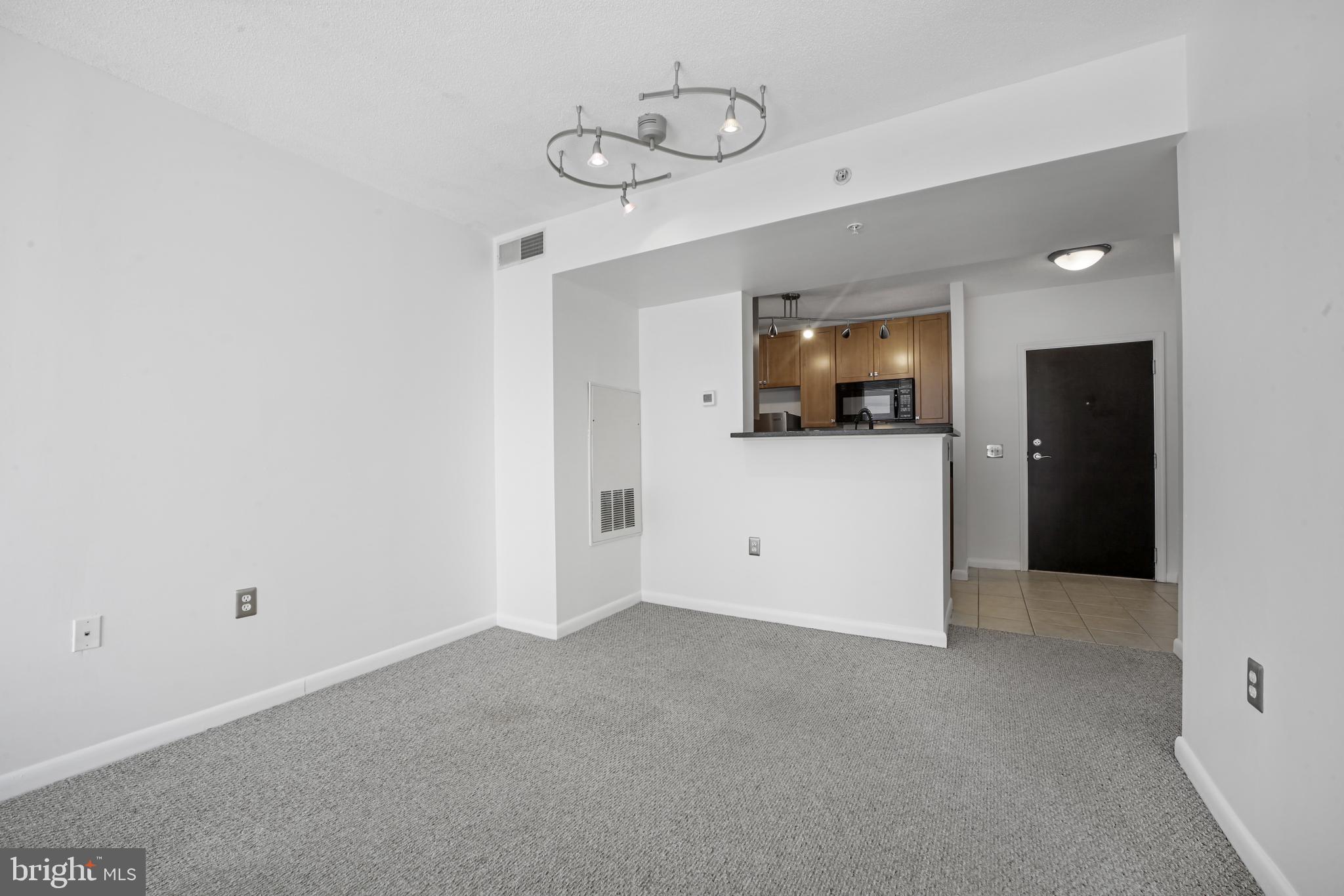 851 North Glebe Road, Unit 1608 Arlington, VA 22203 - Photo 5 of 24 a view of an empty room with wooden floor and windows