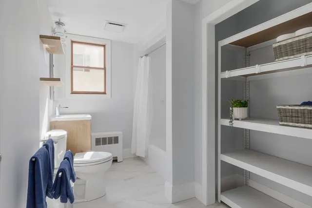 a bathroom with a toilet a sink and a window