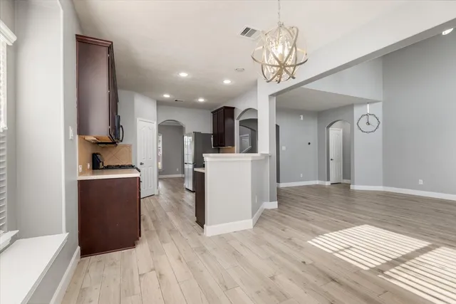 a view of a kitchen with wooden floor and a refrigerator
