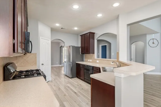 a kitchen with stainless steel appliances a sink stove and refrigerator