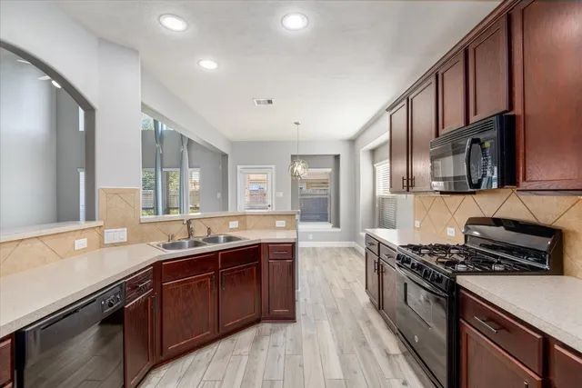 a kitchen with stainless steel appliances granite countertop a sink stove and cabinets