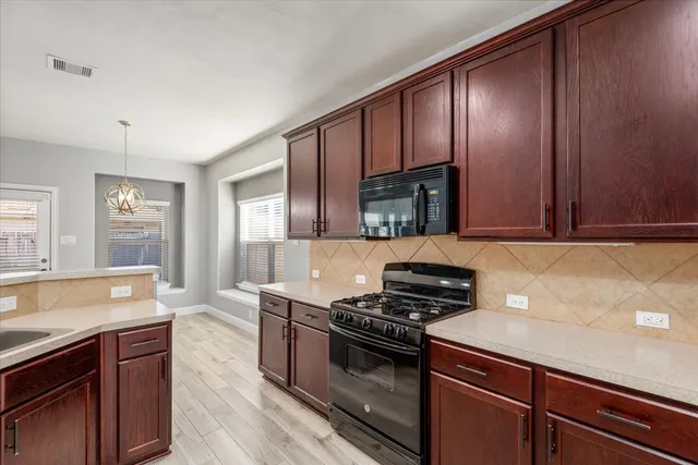 a kitchen with granite countertop stainless steel appliances and wooden cabinets