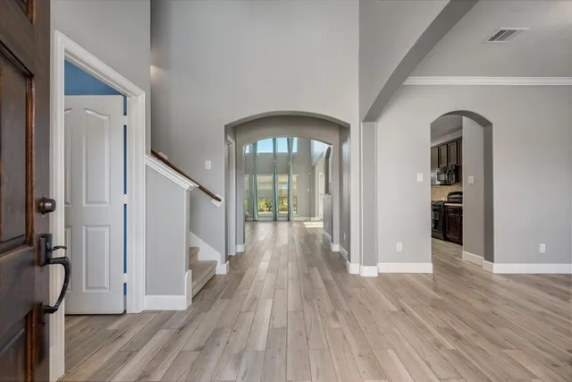 a view of a hallway with wooden floor and stairs