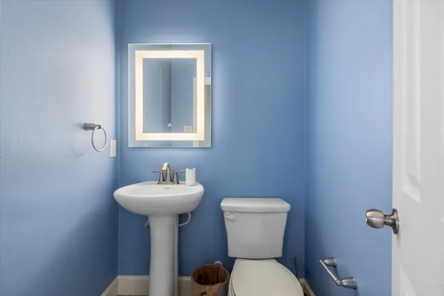a bathroom with a sink mirror and toilet