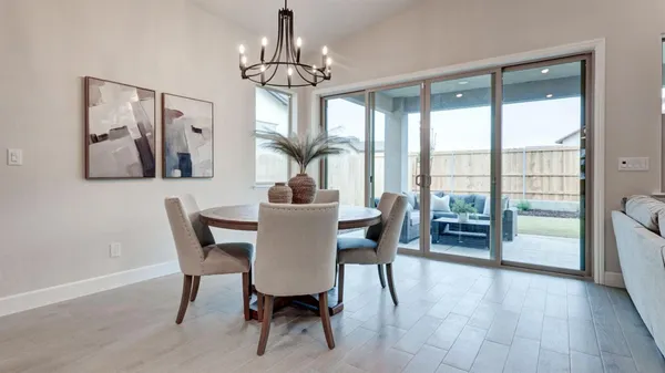 a view of a dining room with furniture a chandelier and wooden floor