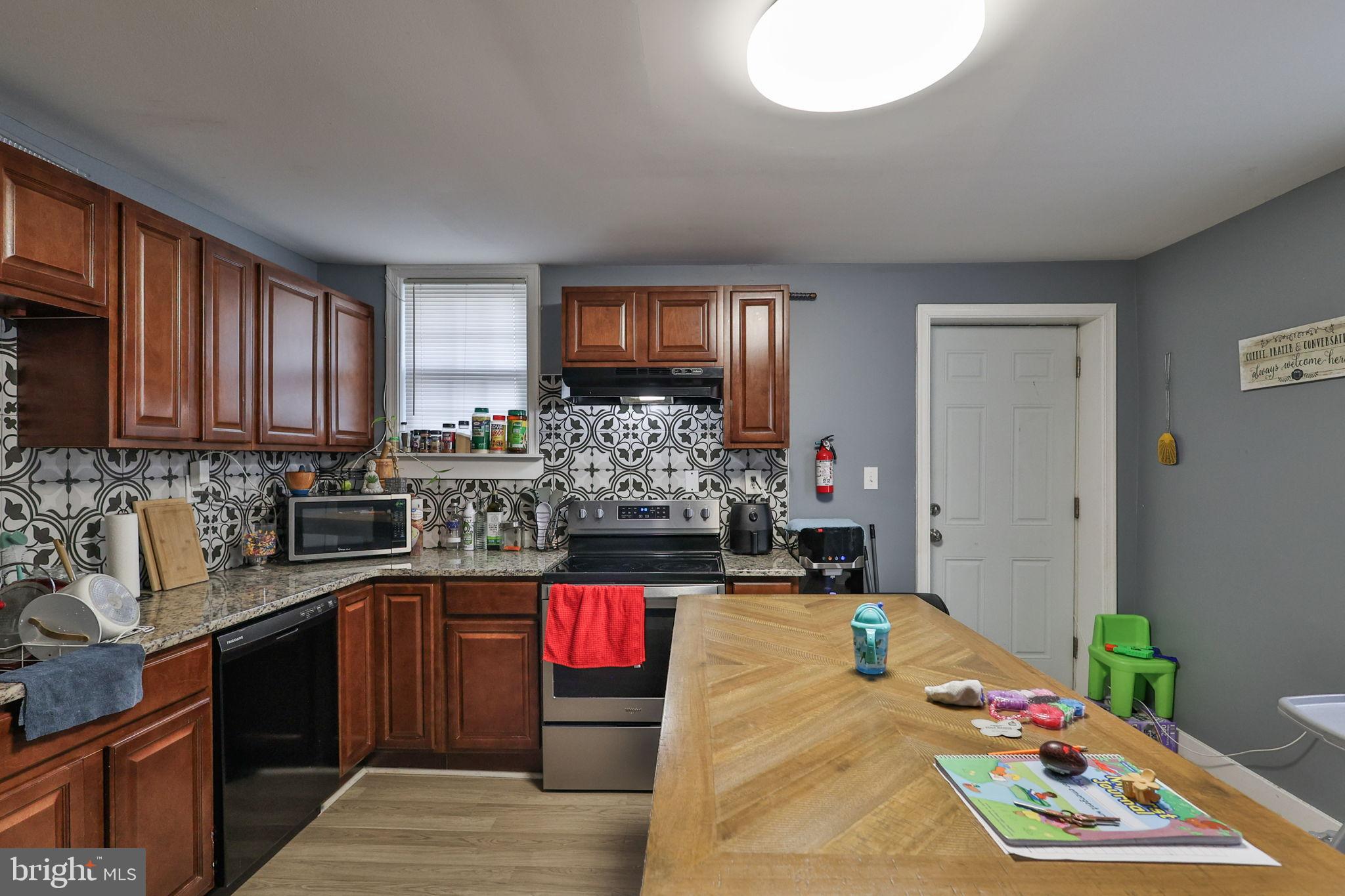 714 Ward Street Chester, PA 19013 - Photo 15 of 40 a kitchen with granite countertop a sink stove and cabinets
