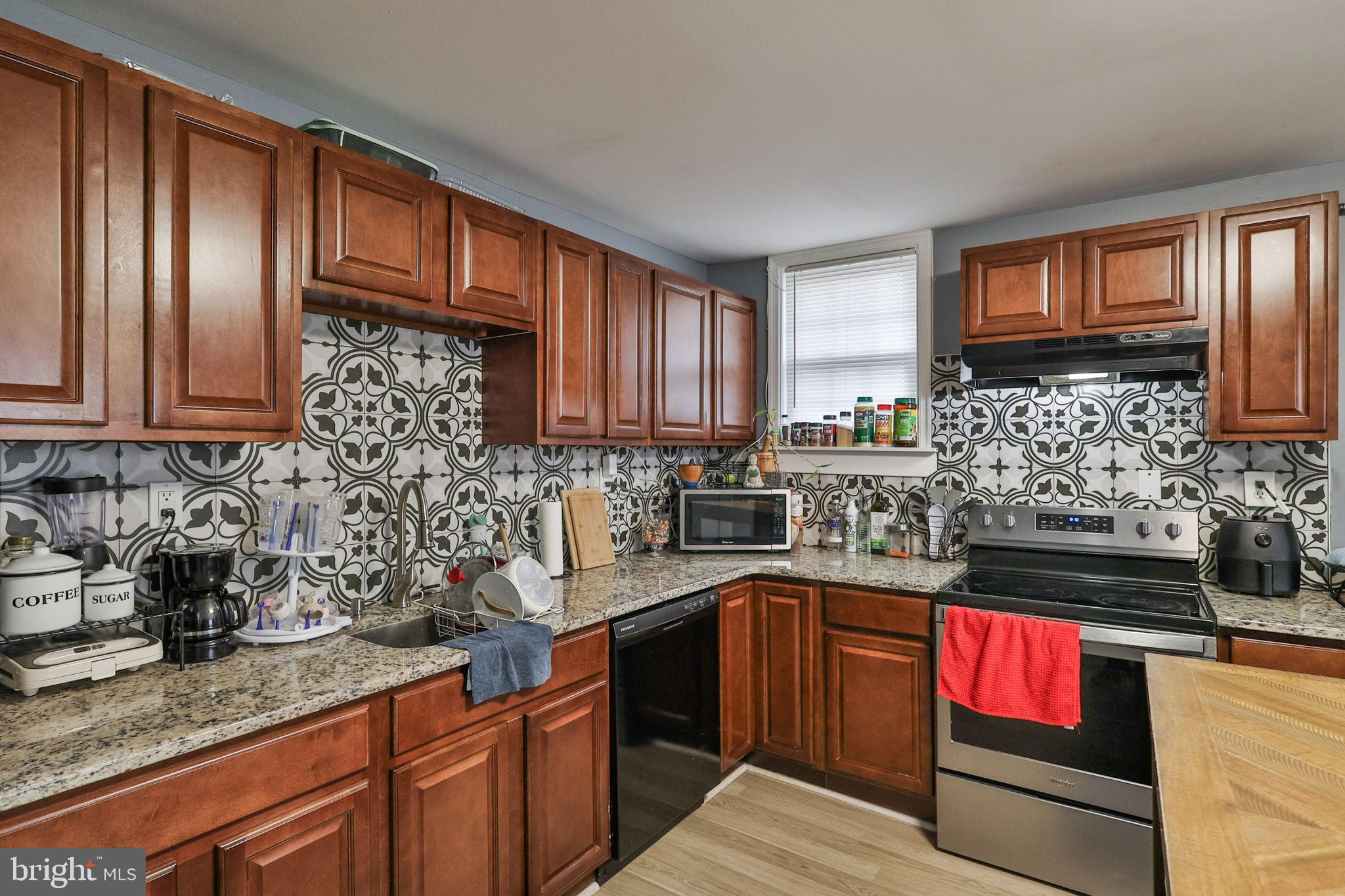 714 Ward Street Chester, PA 19013 - Photo 17 of 40 a kitchen with stainless steel appliances granite countertop a stove a sink and a microwave
