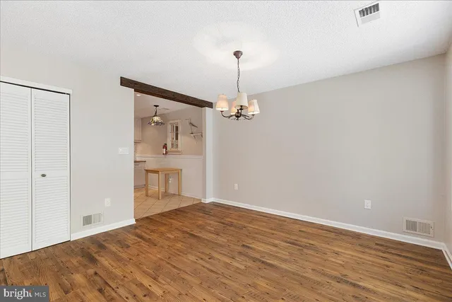 a view of a room with wooden floor closet and windows