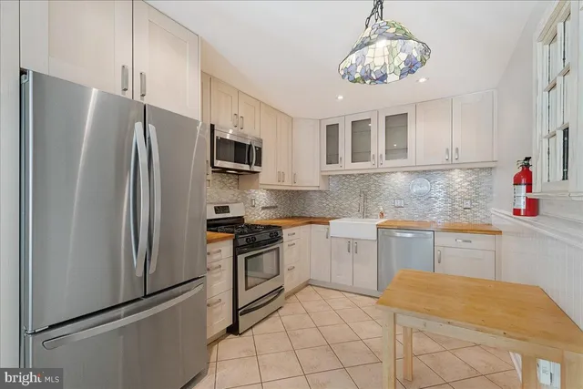 a kitchen with stainless steel appliances granite countertop a refrigerator sink and microwave