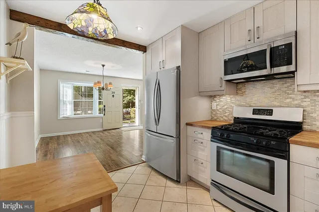 a kitchen with stainless steel appliances granite countertop a stove a refrigerator and a microwave