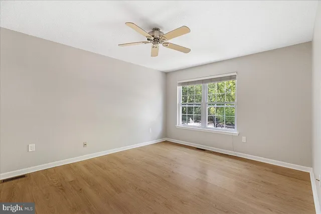 a view of a room with a ceiling fan and a window