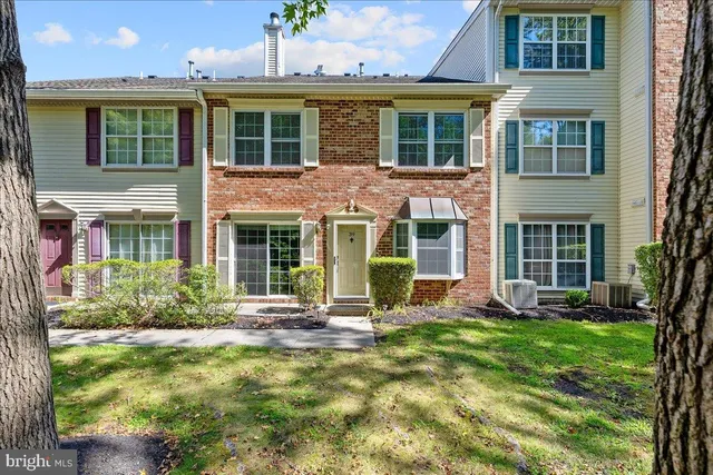 front view of a brick house with a yard