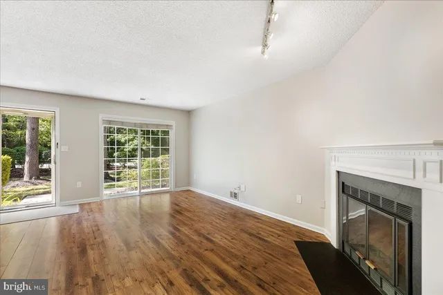 wooden floor fireplace and windows in an empty room
