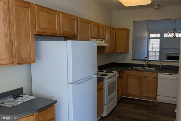 a kitchen with a refrigerator stove and wooden cabinets