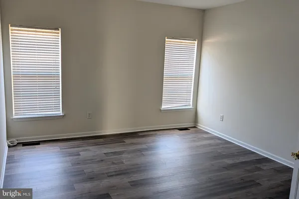 an empty room with wooden floor and a window