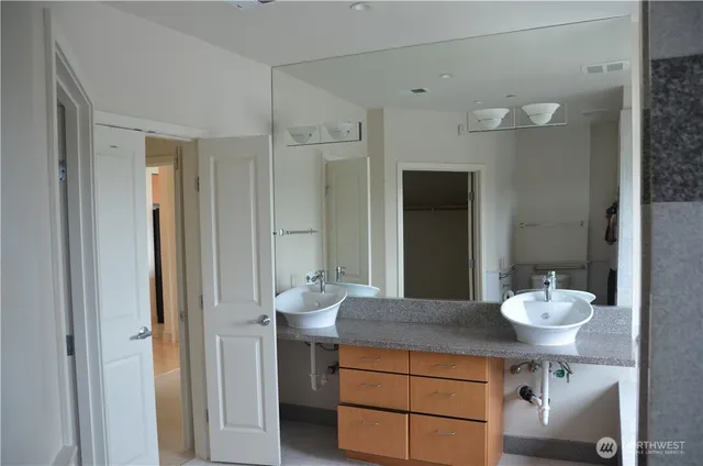 a bathroom with a granite countertop sink and a mirror