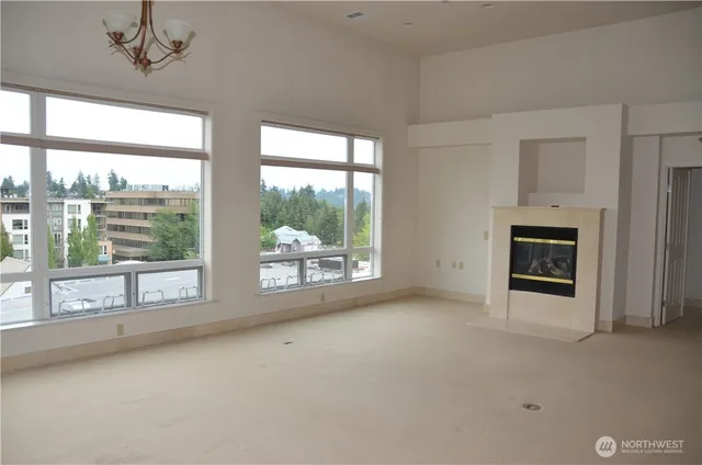 a view of an empty room with a fireplace and a window
