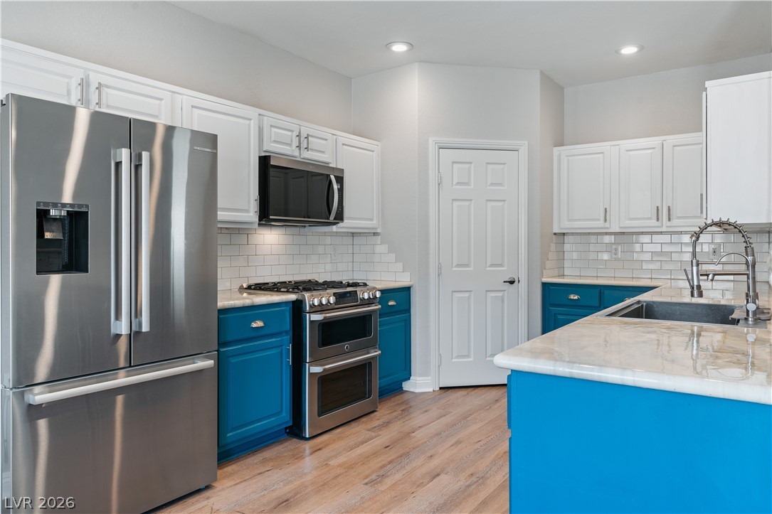1328 Spice Ridge Court Henderson, NV 89012 - Photo 10 of 51 This brightly lit kitchen features sleek countertops and modern appliances, perfect for culinary endeavors.