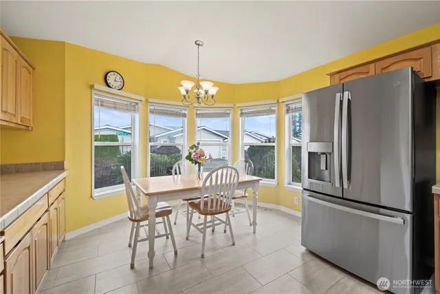 a view of a dining room with furniture a chandelier and a large window