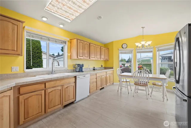 a kitchen with white cabinets and a window