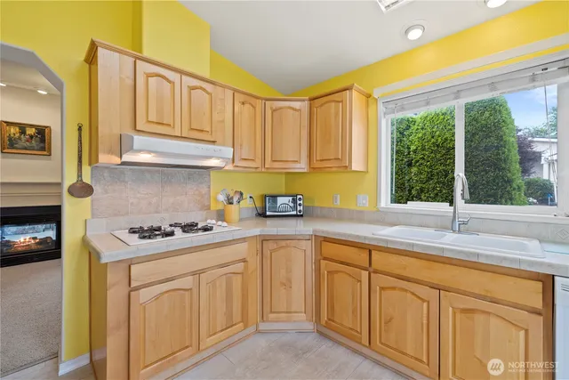 a kitchen with granite countertop a sink and white cabinets