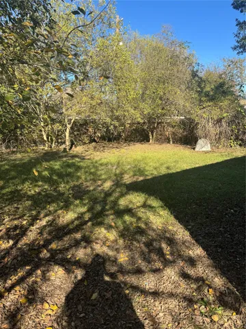 a view of a yard with wooden fence
