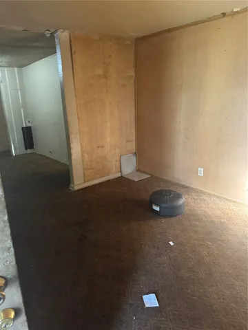 a view of a small space with wooden floor and a window