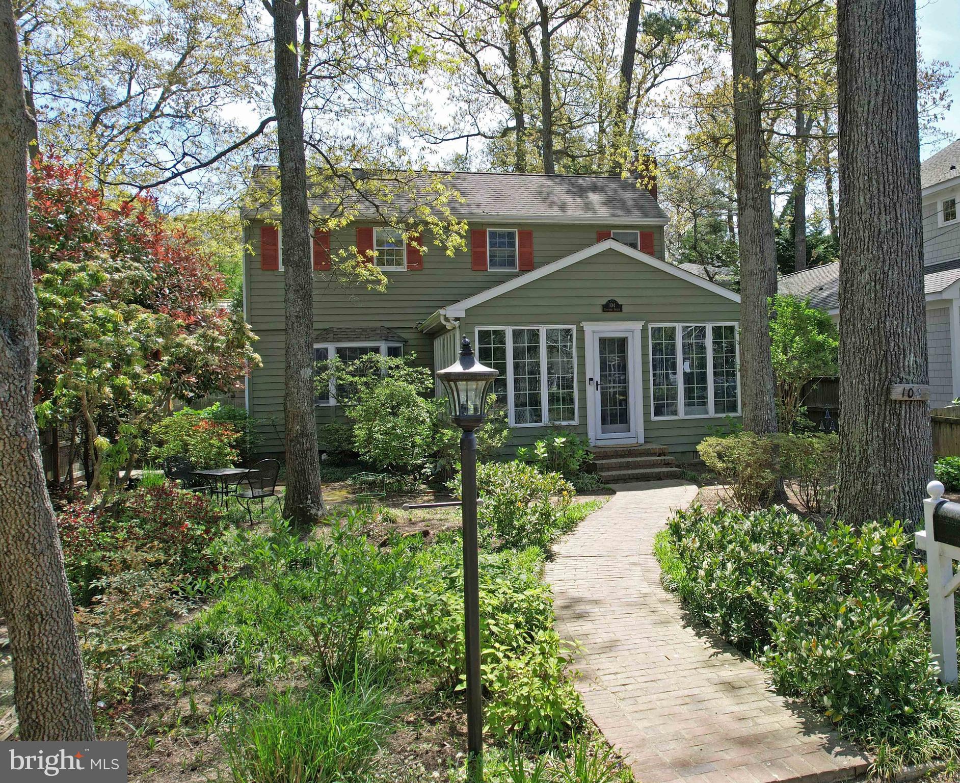 a front view of a house with a yard and fountain in middle