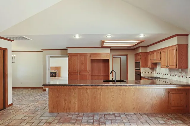a view of kitchen with stainless steel appliances granite countertop a refrigerator and a sink