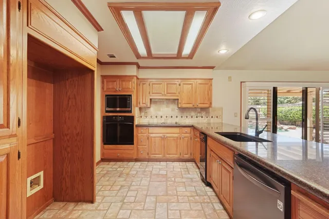 a large kitchen with stainless steel appliances granite countertop a refrigerator and a sink