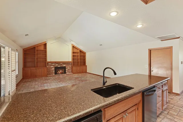 a kitchen with a sink and a stove with wooden floor