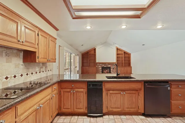 a kitchen with stainless steel appliances granite countertop a sink stove and cabinets