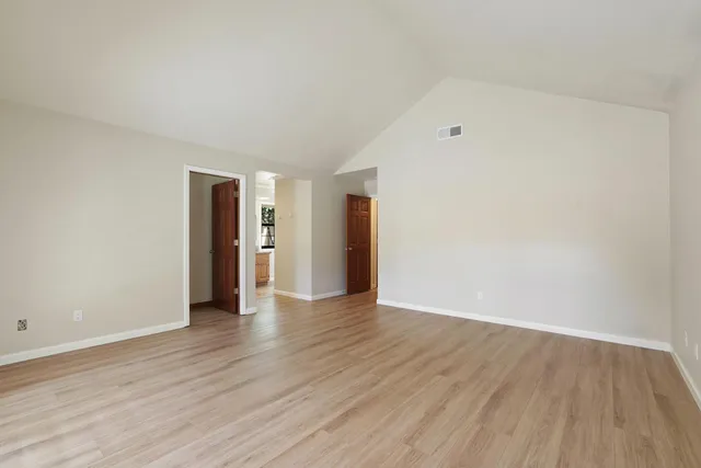 a bathroom with a granite countertop double vanity sink a mirror and a bathtub