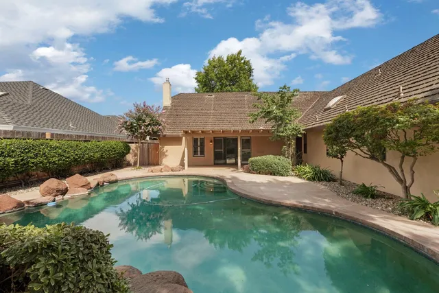 a front view of a house with a garden and yard
