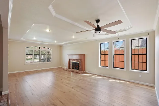 a view of an empty room with a fireplace and a window