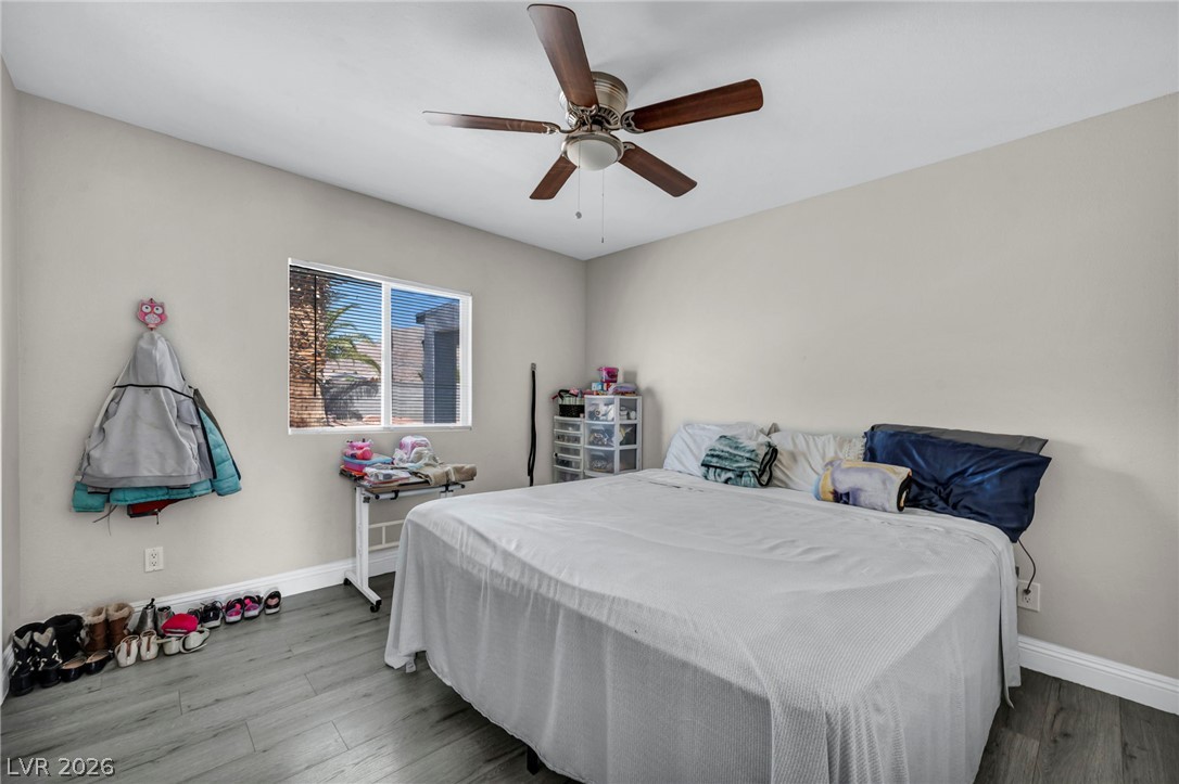 5882 Rio Tinto Way Las Vegas, NV 89110 - Photo 15 of 56 Well-lit sleeping quarters featuring practical wood-look flooring and a functional overhead fan.