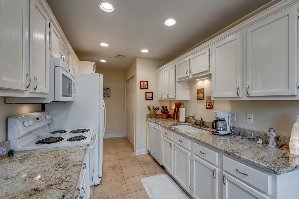 1056 General George Patton Road, Unit 1056 Nashville, TN 37221 - Photo 12 of 30 a kitchen with granite countertop a sink a stove and refrigerator