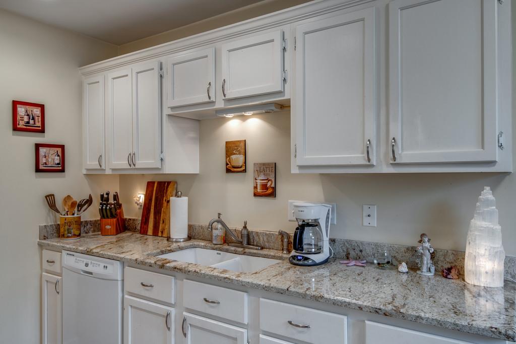 1056 General George Patton Road, Unit 1056 Nashville, TN 37221 - Photo 13 of 30 a kitchen with granite countertop white cabinets and a sink