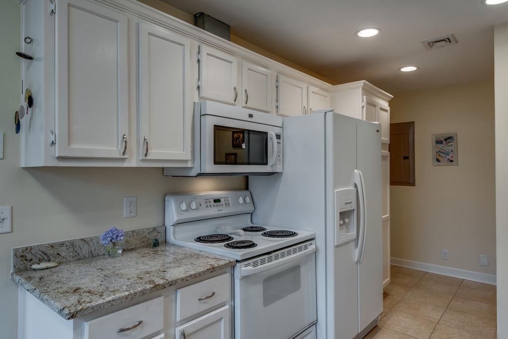 1056 General George Patton Road, Unit 1056 Nashville, TN 37221 - Photo 14 of 30 a kitchen with granite countertop a refrigerator stove and microwave