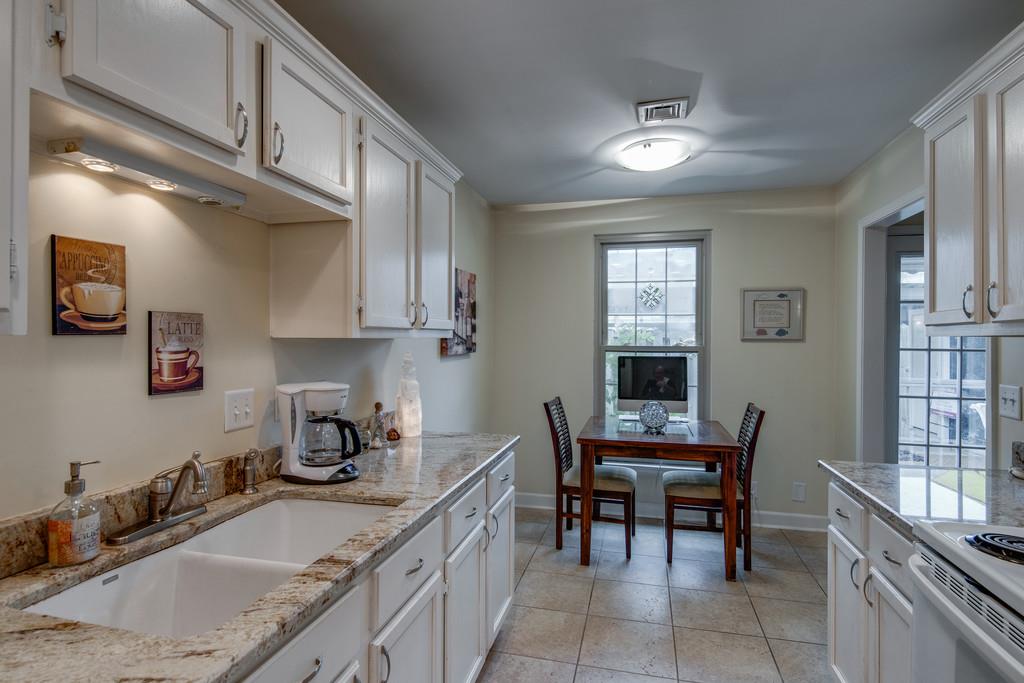 1056 General George Patton Road, Unit 1056 Nashville, TN 37221 - Photo 15 of 30 a kitchen with granite countertop a sink chairs and cabinets