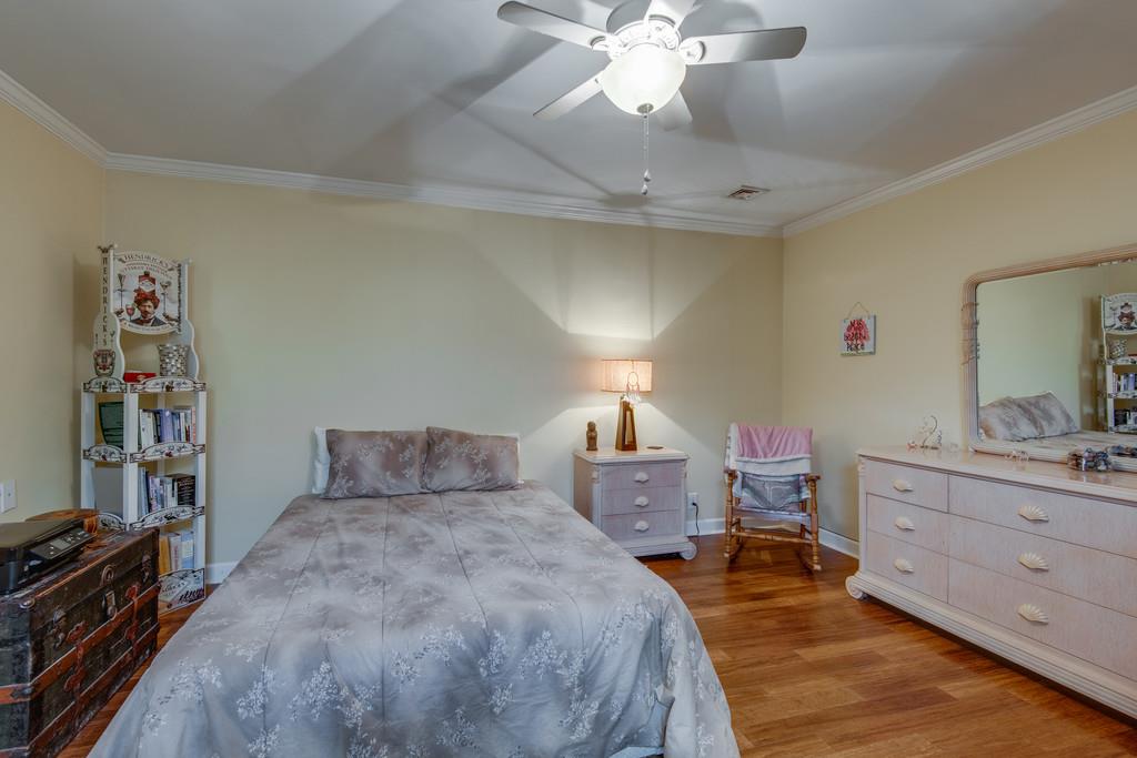 1056 General George Patton Road, Unit 1056 Nashville, TN 37221 - Photo 17 of 30 a bedroom with a bed and a chandelier