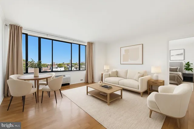 a living room with furniture a rug a lamp and a large window