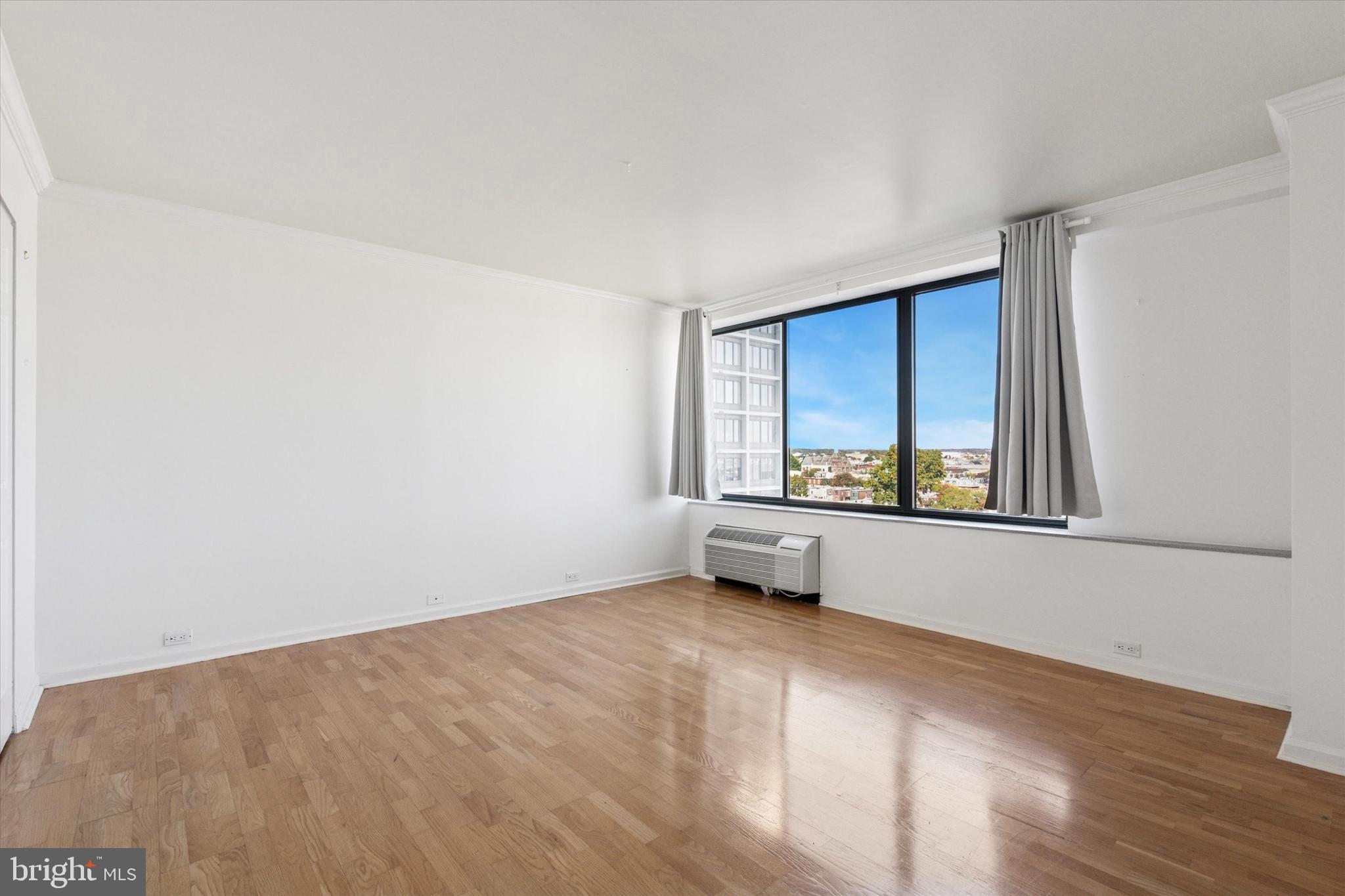 2001 Hamilton Street, Unit 1205 Philadelphia, PA 19130 - Photo 18 of 34 a view of an empty room with wooden floor and a window