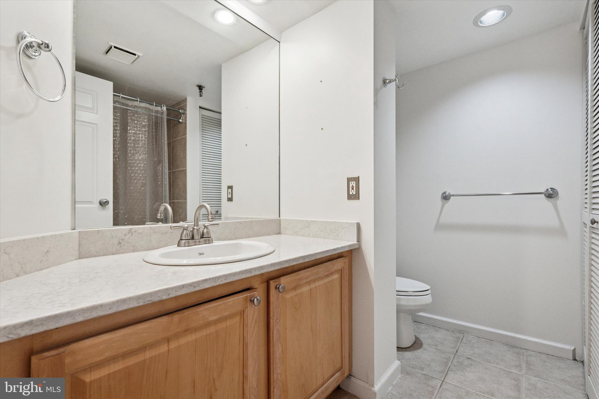 2001 Hamilton Street, Unit 1205 Philadelphia, PA 19130 - Photo 21 of 34 a bathroom with a granite countertop sink mirror vanity and toilet